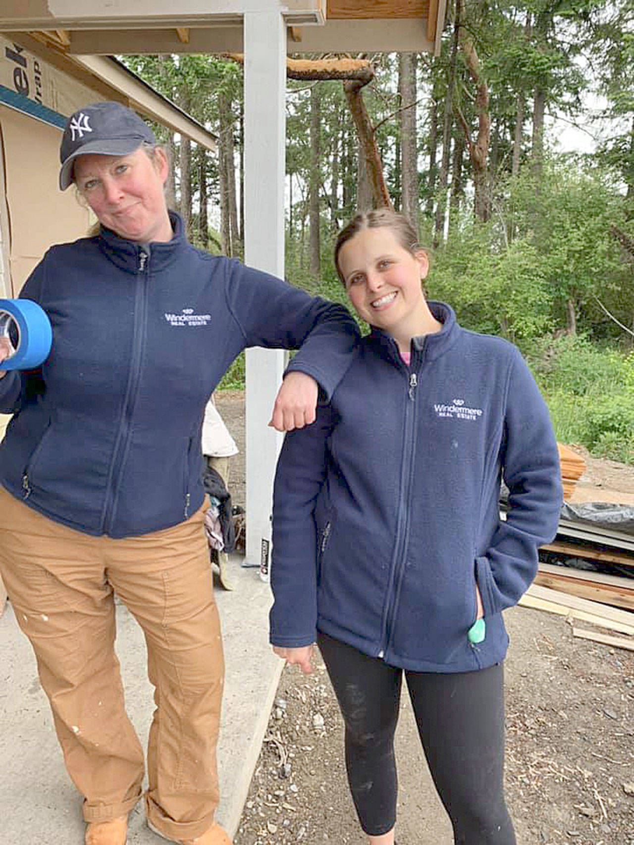 Amanda Steurer-Zamora, left, and Robyn Garing prepare to mask off parts of a building before priming.