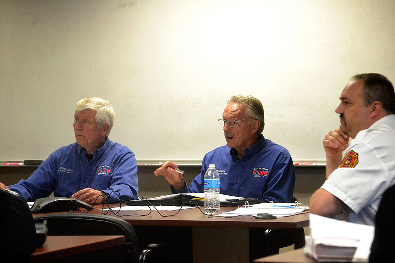 Mike Gawley and James Barnfather, fire commissioners for Clallam County Fire District 3, and Fire Chief Ben Andrews listen in on a discussion about the possibility of renewing the district’s 10-year EMS levy, which accounts for 25 percent of its annual budget. (Matthew Nash/Olympic Peninsula News Group)