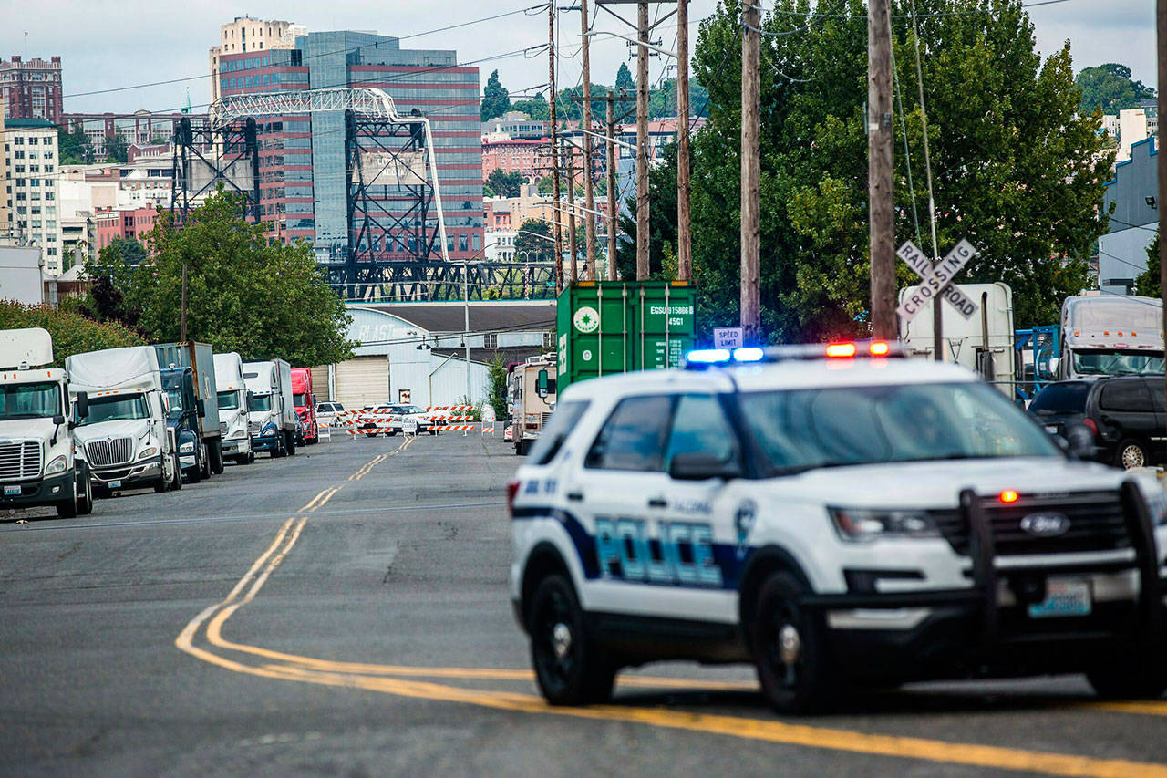 A police officer guards the front of a road block near the Northwest Detention Center on Saturday. (Rebekah Welch/The Seattle Times via AP)