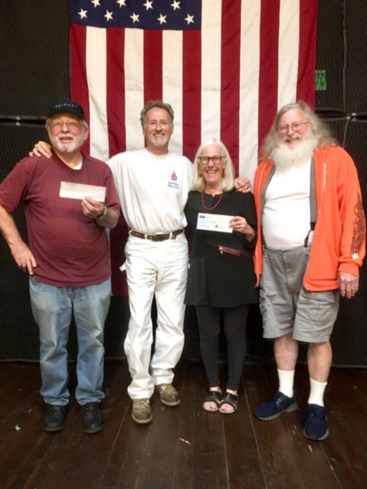 Legion Finance Officer Andy Okinczyc, left, contractor Quinn Hampton of Sequim, Port Townsend Film Festival Executive Director Janette Force and American Legion Cmdr. Chuck Thomas pose with the two checks that were written to start upgrades on the Legion’s hall. (Port Townsend Film Festival)