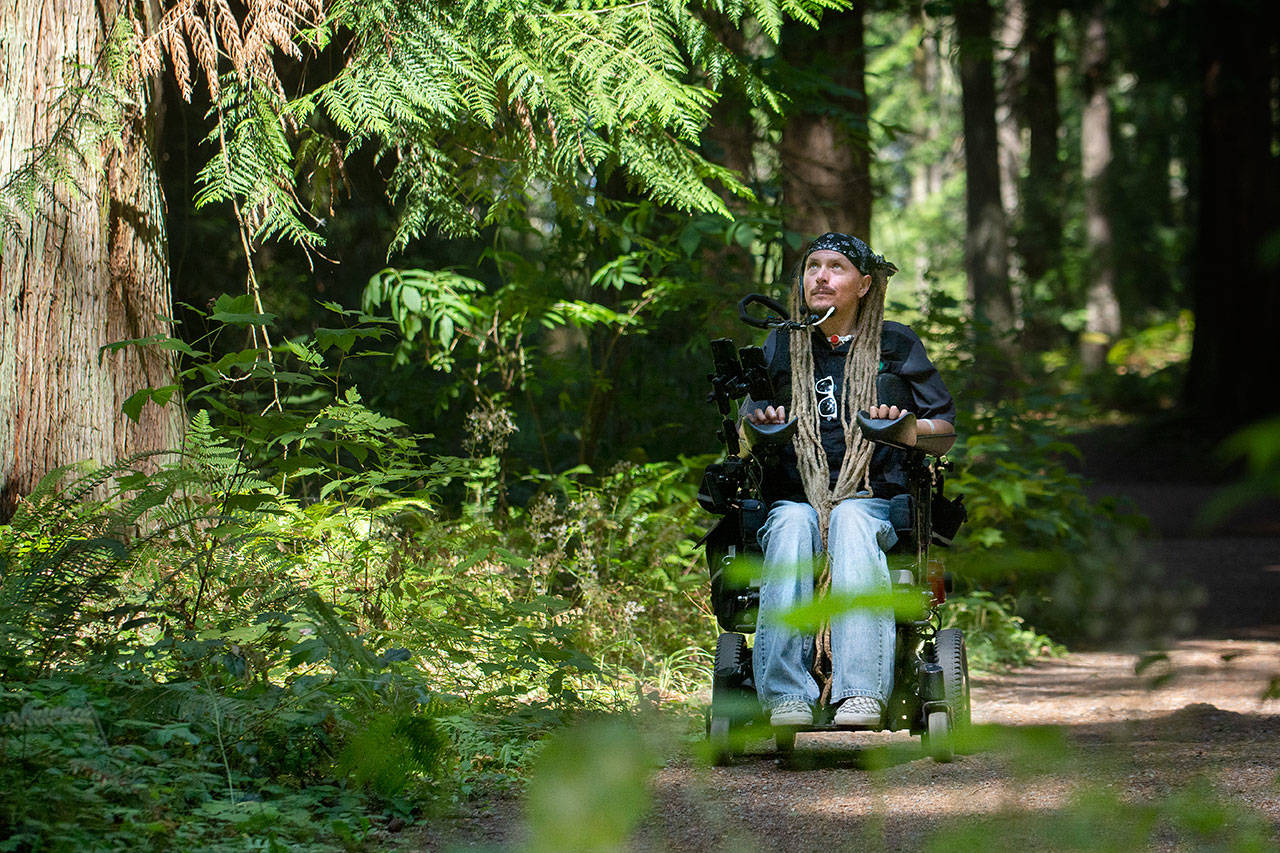 Ian Mackay of Agnew rides his wheelchair through Robin Hill Farm County Park. Mackay is preparing to host a group ride on the Olympic Discovery Trail from Aug. 23 to 25. (Jesse Major/Peninsula Daily News)