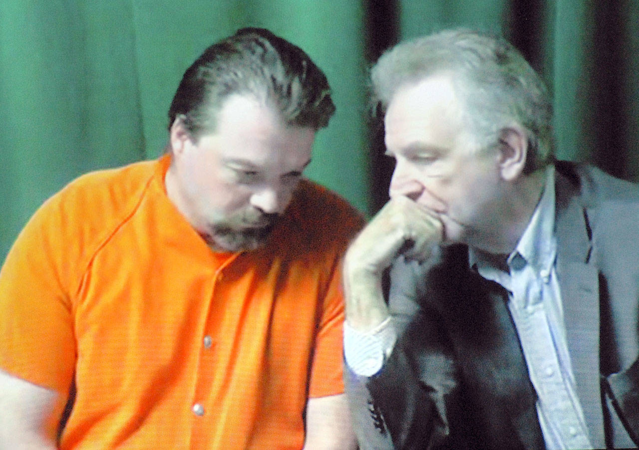 Matthew Timothy Wetherington, left, confers with public defender John Hayden on a video link to the courtroom during Wetherington’s arraignment in Clallam County Superior Court in Port Angeles. (Keith Thorpe/Peninsula Daily News)