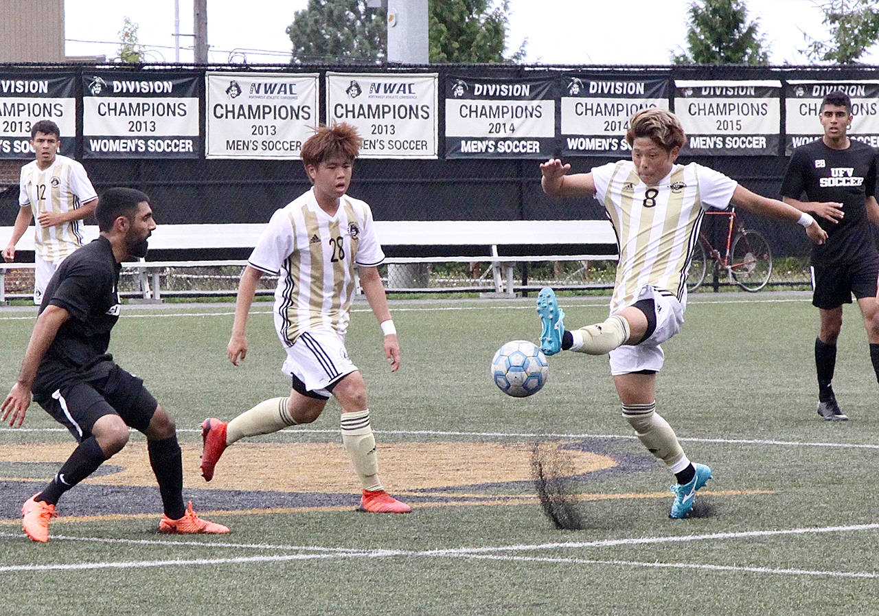 Dave Logan/for Peninsula Daily News Peninsula College’s Yuya Yamamoto, right, settles the ball while defended by a University of the Fraser Valley defender as teammate Jeong Hyun Kang looks on.