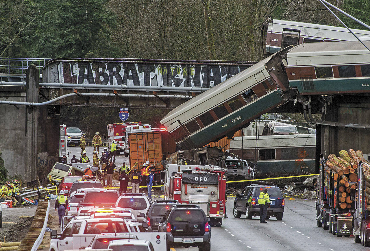 In this file photo from Dec. 18, 2017, cars from an Amtrak train that derailed lie spilled onto Interstate 5 in DuPont. (Peter Haley/The News Tribune via AP)