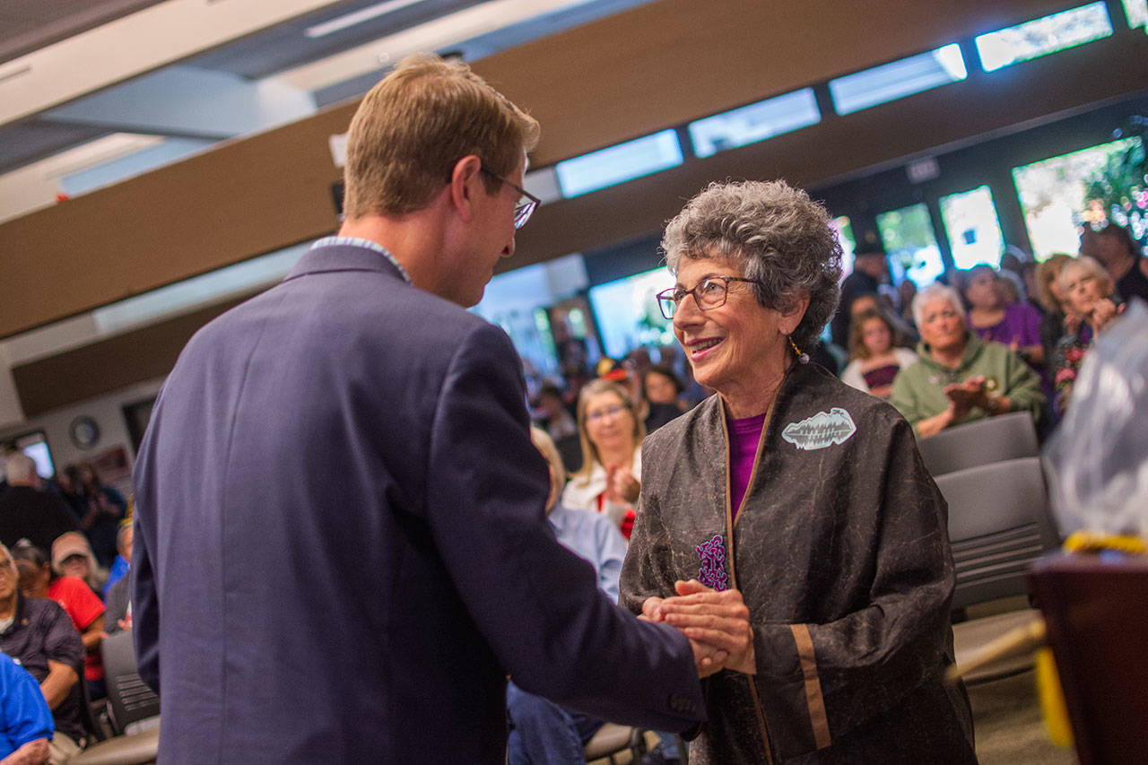 U.S. Rep. Derek Kilmer hands a pin to Shele Kinkead of Forks during a pinning ceremony for Vietnam War Era veterans at Peninsula College in Forks on Wednesday. Kinkead accepted the pin for her late husband who served in the U.S. Coast Guard during the Vietnam War. (Jesse Major/Peninsula Daily News)