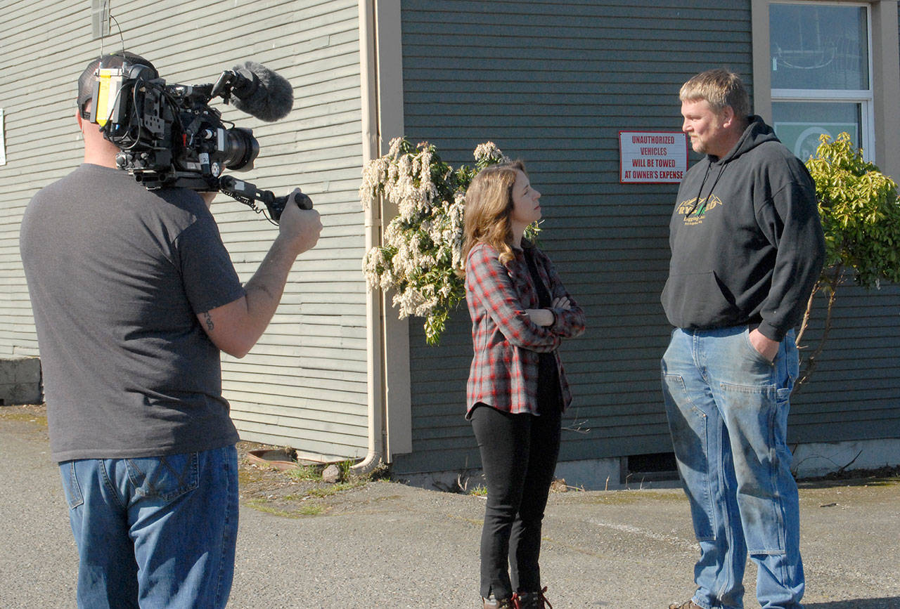 The state Commissioner of Public Lands Hilary Franz, center, speaks with Jason Rygaard of Port Angeles-based Rygaard Logging Inc. in March as cameraman Brian Andrews of Original Productions tapes their talk for an episode of “Ax Men” on the History Channel set for tonight. (Keith Thorpe/Peninsula Daily News)