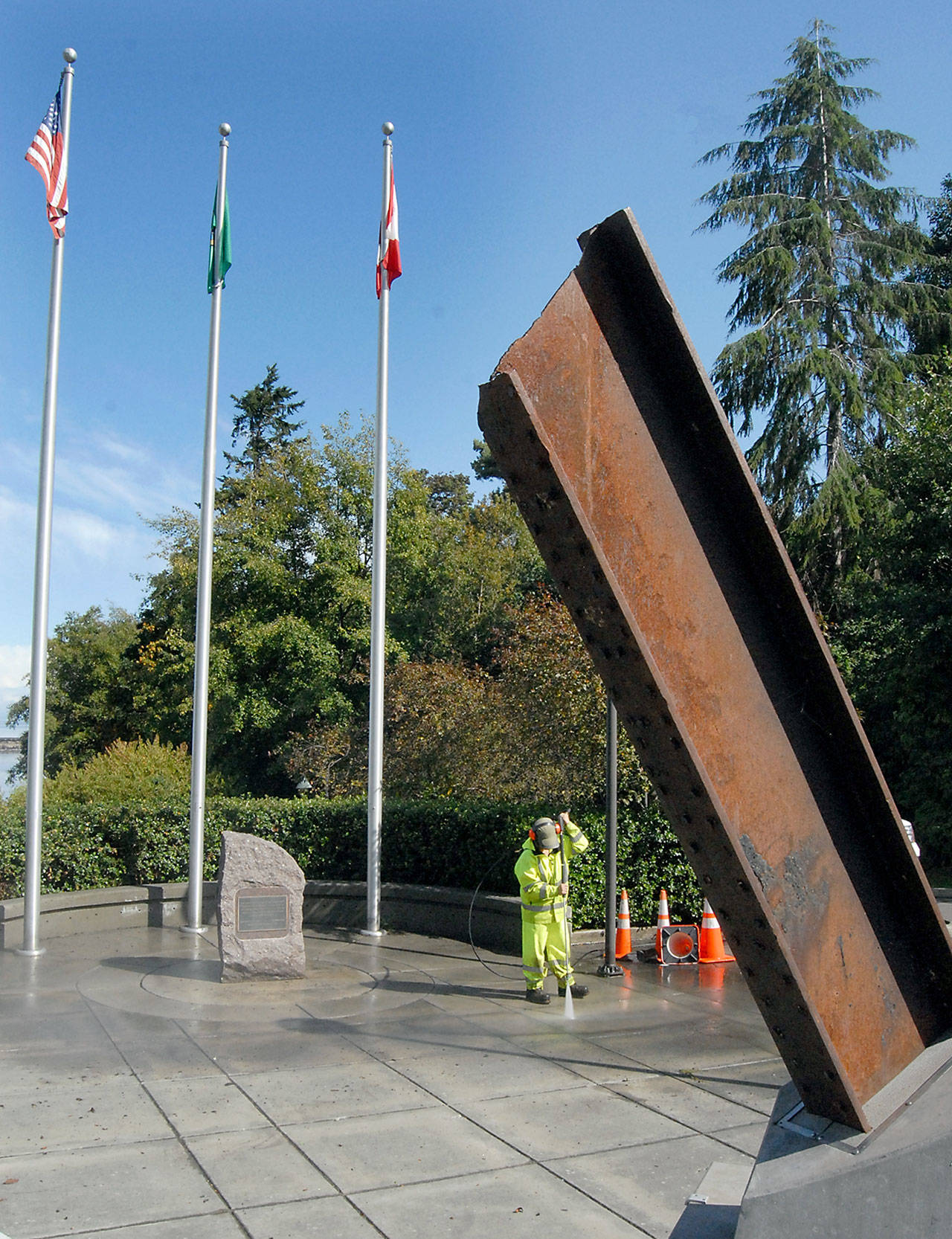 Tera Dummitt of the Port Angeles Parks and Recreation Department pressure-washes the plaza surrounding the I-beam from the World Trade Center at 9/11 Memorial Waterfront Park on Tuesday in Port Angeles in preparation for today’s ceremony commemorating the 18th anniversary of the terrorist attacks on New York City and Washington, D.C. (Keith Thorpe/Peninsula Daily News)