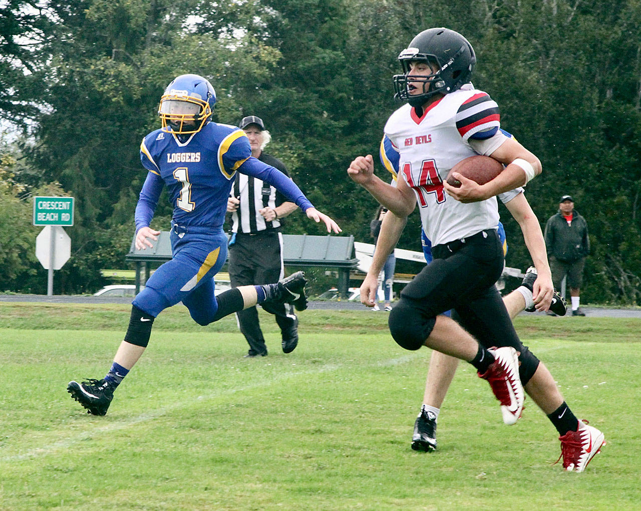 Dave Logan/for Peninsula Daily News Neah Bay’s Robert Richardson, right, breaks a long run while being pursued by Crescent’s Weston Hart.