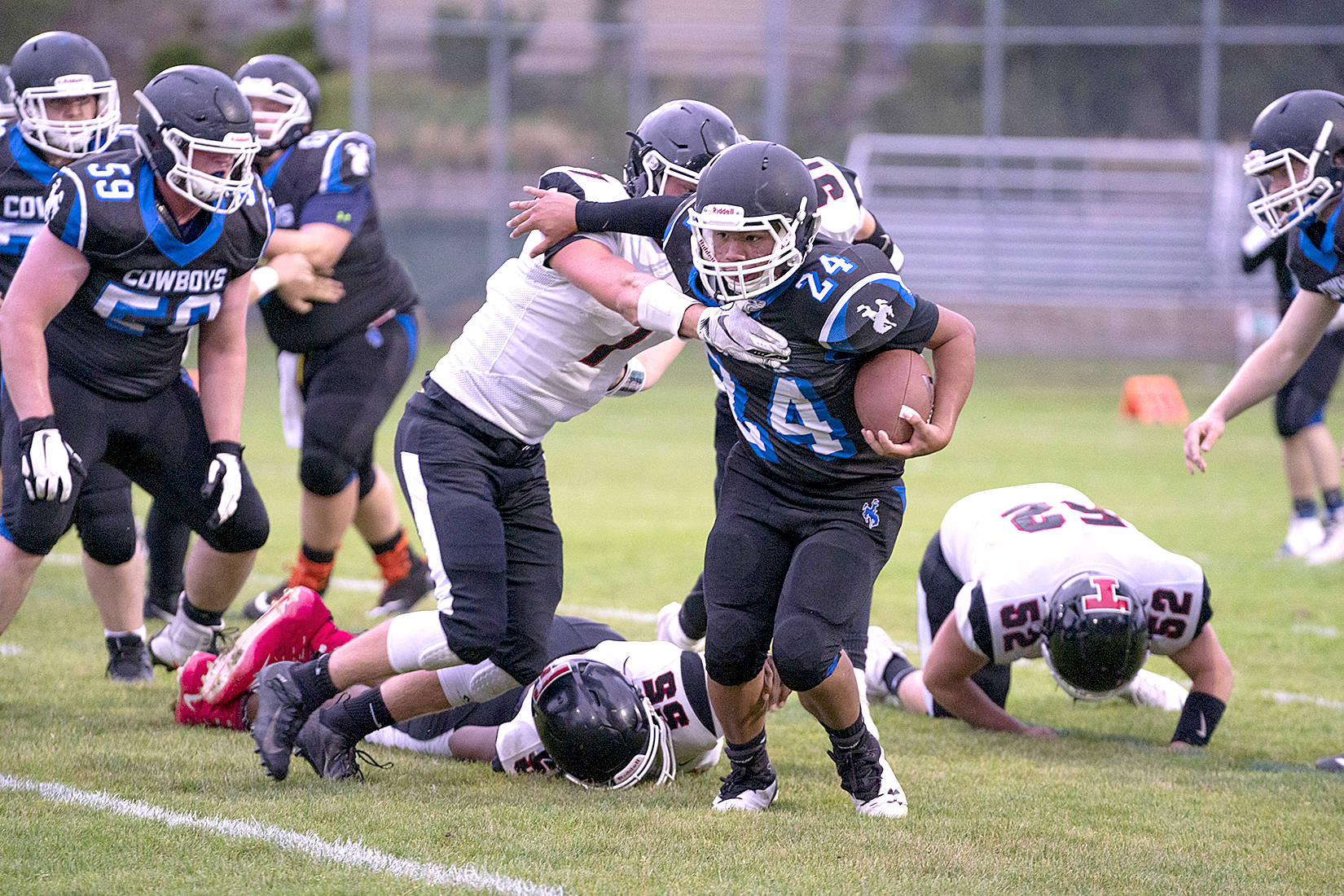 <strong>Steve Mullensky</strong>/for Peninsula Daily News                                Chimacum’s Anson Jones in the Cowboys’ new black uniforms runs for yardage in a game against the Tenino Beavers on Friday at Memorial Field in Port Townsend.