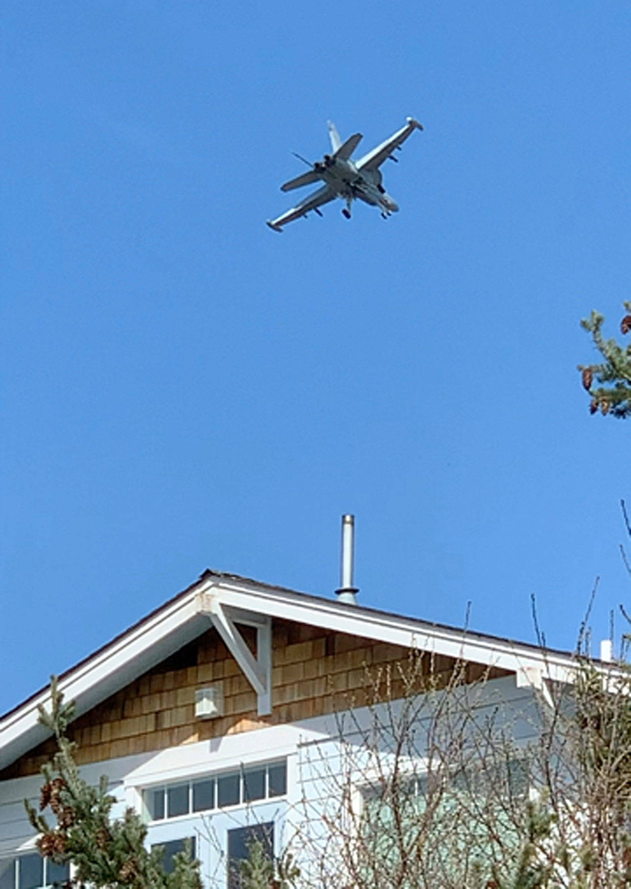 This March 28 photo from video shows a Navy jet flying above the home of his neighbors Marge Plecki and Michael King in Coupeville. Portin, Plecki and King are among three dozen residents who filed a federal lawsuit against the Navy last week, saying the incessant noise from expanded flight training operations at a small nearby landing strip have cost them the use of their properties and made their lives miserable. (Bradley Portin via The Associated Press)