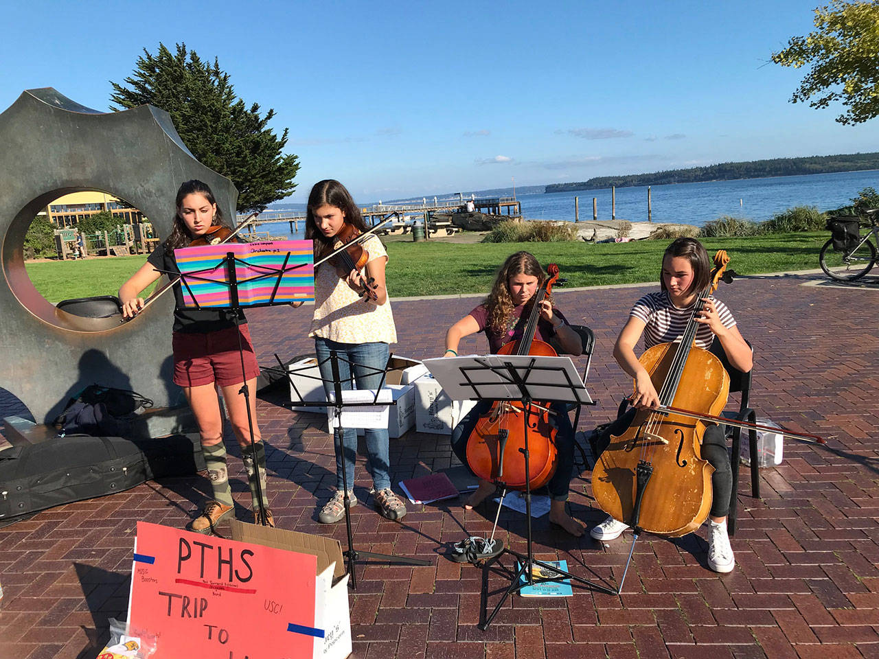 Port Townsend High School orchestra students Chloe Lampert, left, Magdaline Ferland, Adeline Gellert DePalma and Zoe Cook perform near Pope Marine Park on Water Street during the Port Townsend Film Festival to help raise money for their trip to Los Angeles. (Daniel Ferland)