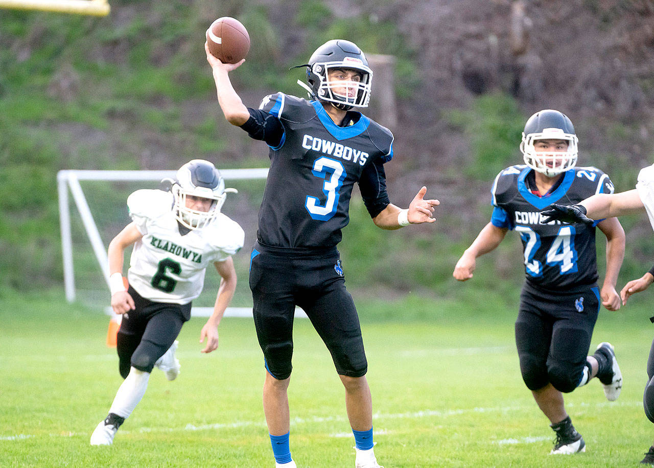 Steve Mullensky/for Peninsula Daily News Cowboy quarterback Henry Brebberman throws a completion during a game in Port Townsend on Friday.