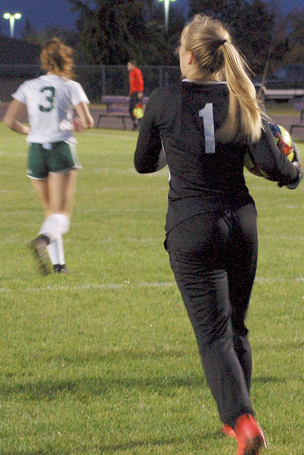 Conor Dowley/Olympic Peninsula News Group Sequim goalkeeper Olivia Hare strides forward after collecting the ball in front of the goal during Sequim’s 2-1 penalty kick shootout win over rival Port Angeles. Hare made several big saves during regulation, then stopped all three penalties she faced from the Roughriders in the shootout to secure a big win for the Wolves and the first loss of the season for PA.