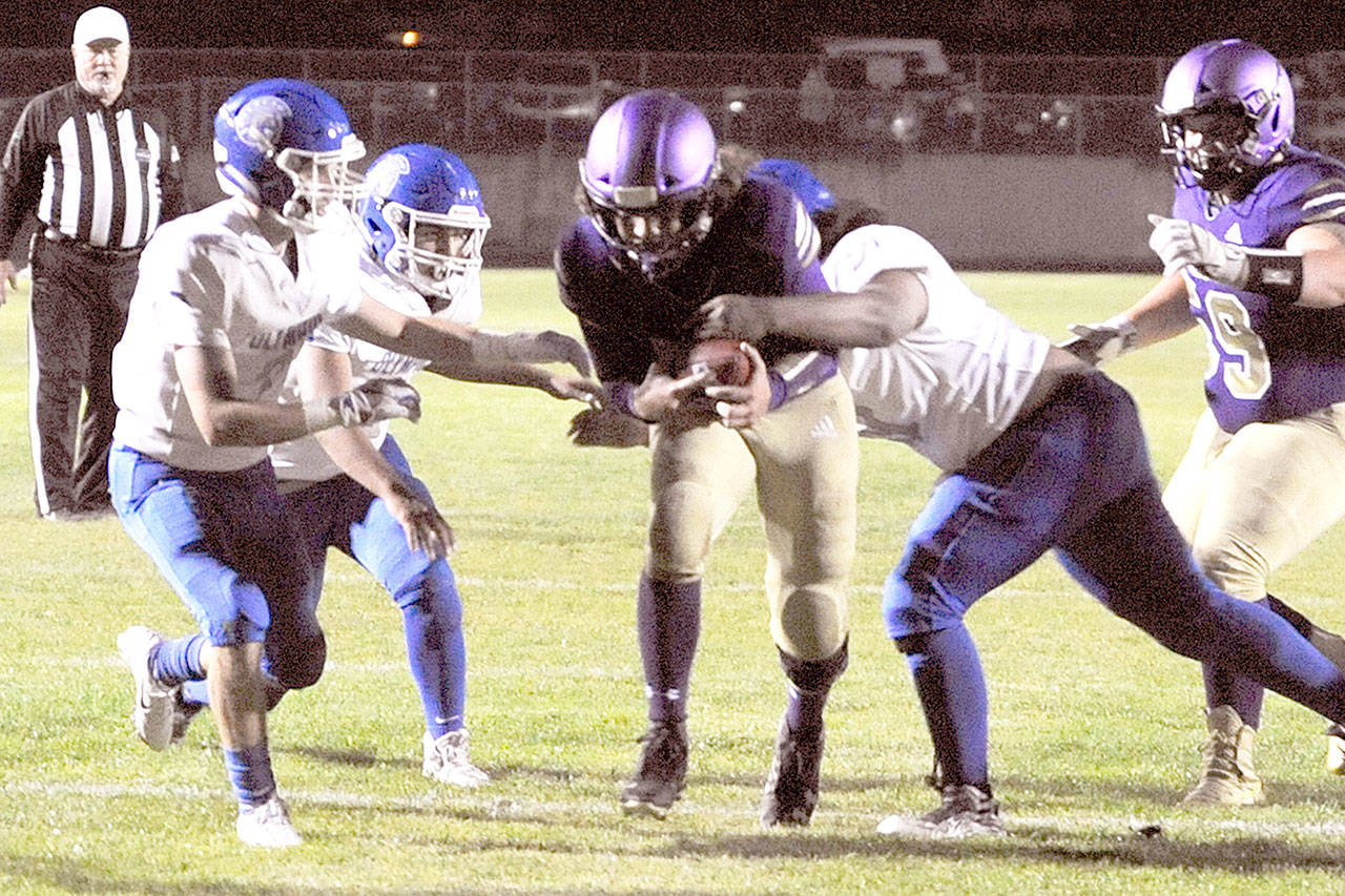 Taig Wiker (center) breaks through the line to score the Sequim Wolves’ second touchdown of the night during their 37-14 win over the Olympic Trojans on Friday. In the junior quarterback’s first action after missing a game and a half with a knee injury, Wiker threw for 170 yards and three touchdowns. (Conor Dowley/Olympic Peninsula News Group)