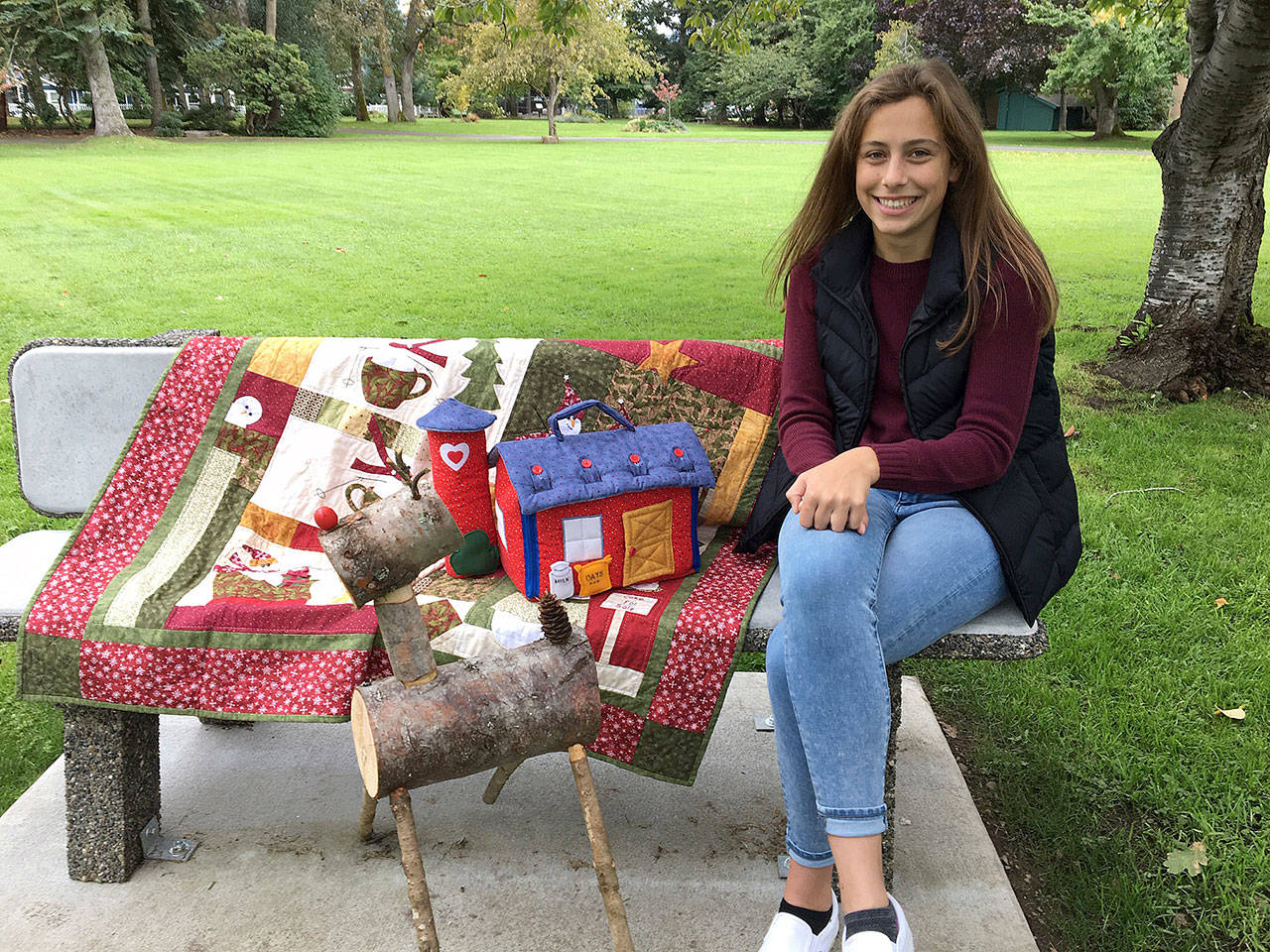 Jessica Dietzman, P.E.O. Chapter JC Star Scholarship nominee, admires the quilted items slated for the Nov. 2 P.E.O. Holiday Bazaar silent auction. (Kathy Cox)