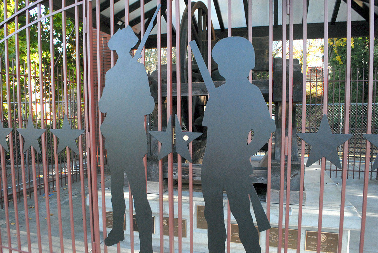 The silhouettes of two Revolutionary War soldiers adorn a decorative fence that was recently installed to protect the Liberty Bell replica from vandalism in Veterans Memorial Park in Port Angeles. (Keith Thorpe/Peninsula Daily News)