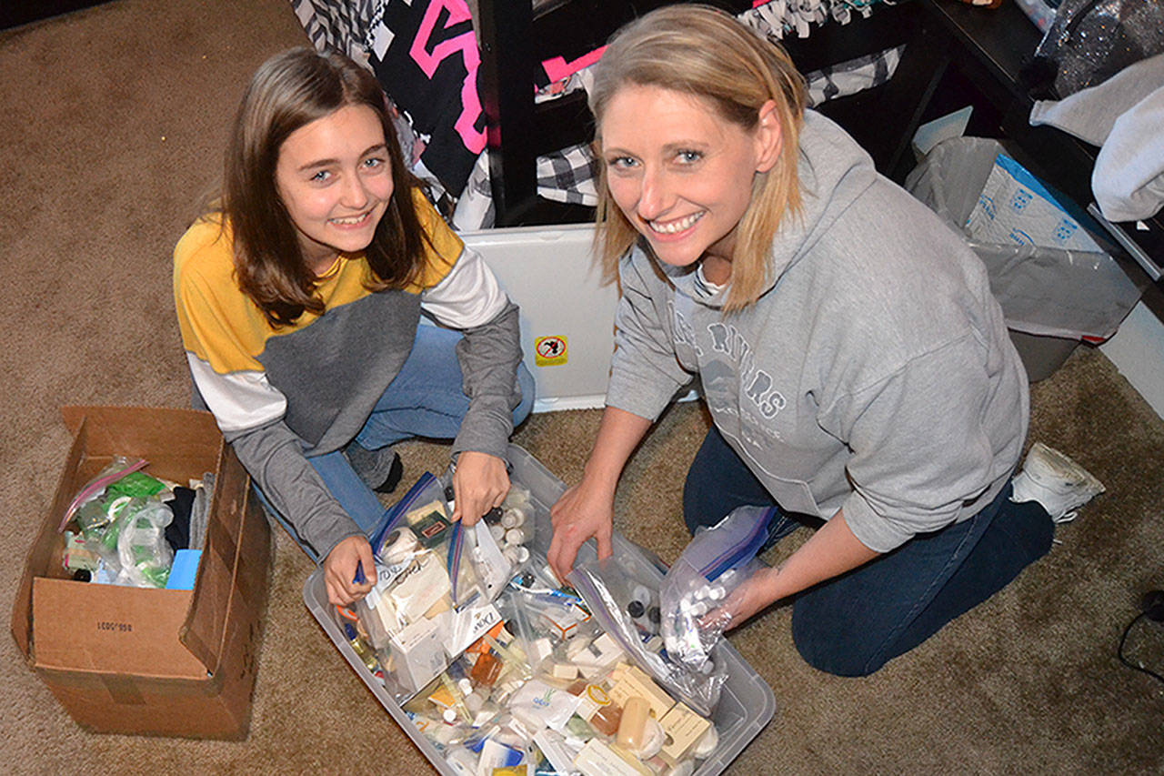 River Jensen, left, continues to gather toiletries with her mom Anna to create bags for people in need this holiday season. (Matthew Nash/Olympic Peninsula News Group)