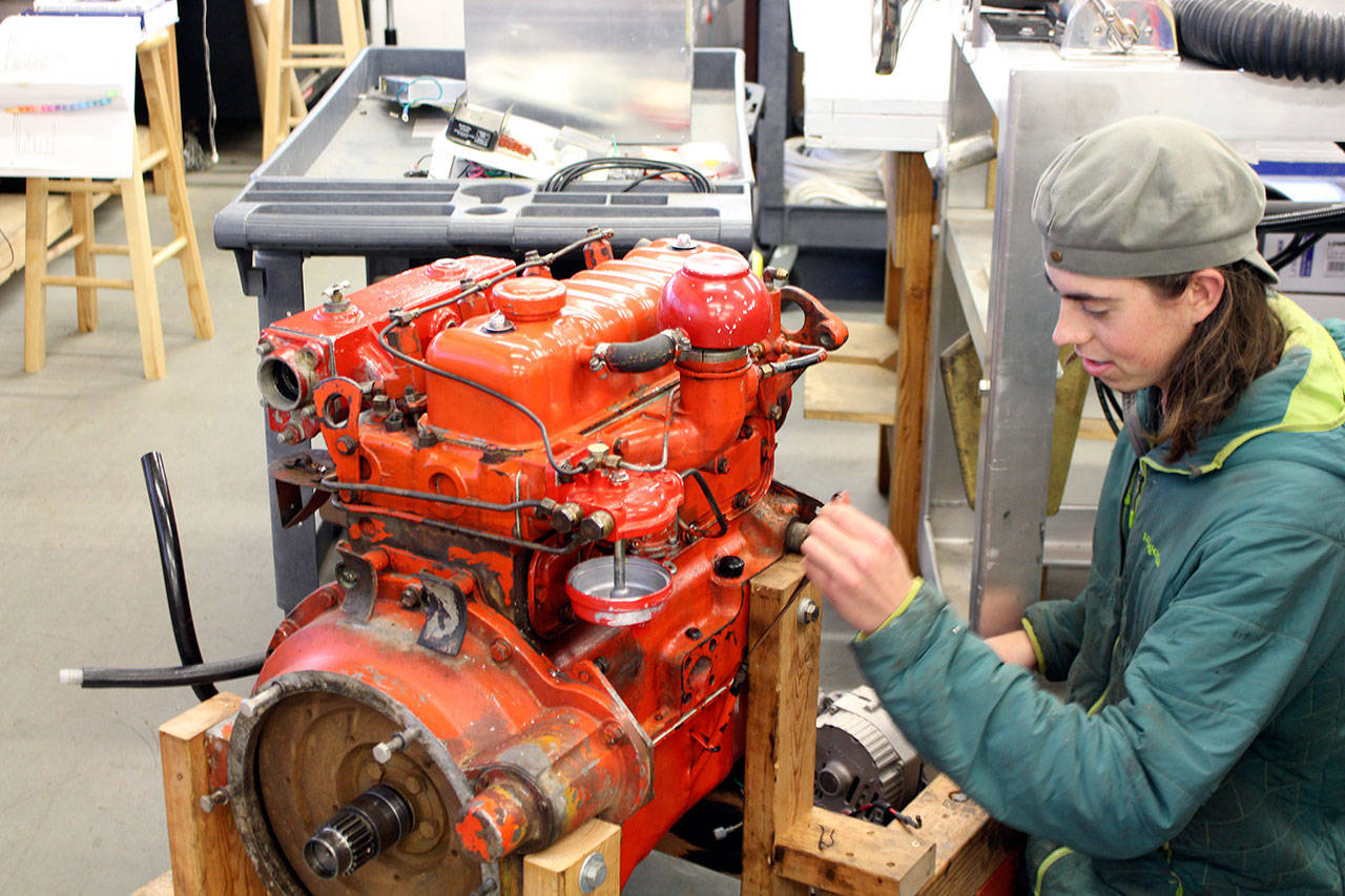 Marine Systems student Demian Detweiler of the Northwest School of Wooden Boat Building works on an engine. (Zach Jablonski/Peninsula Daily News)