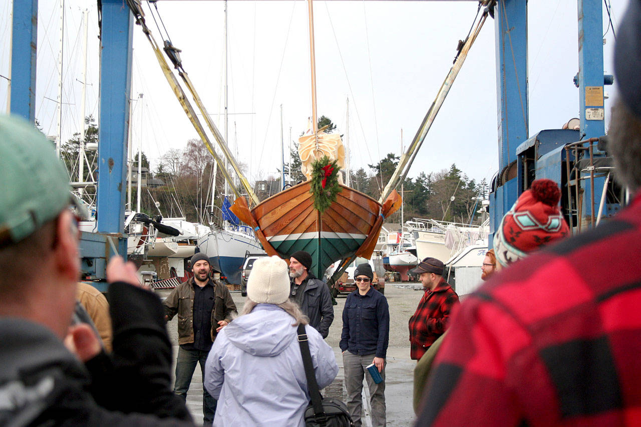 A sailboat, christened Monday as the Crysta Melanie after its new owner’s wife, sits on a hoist before it was launched at Point Hudson Marina in Port Townsend. Its owner, Bob Spychalski, was a student for six months at the Northwest School of Wooden Boatbuilding and spent the majority of his time with four other crew members on the boat. (Brian McLean/Peninsula Daily News)