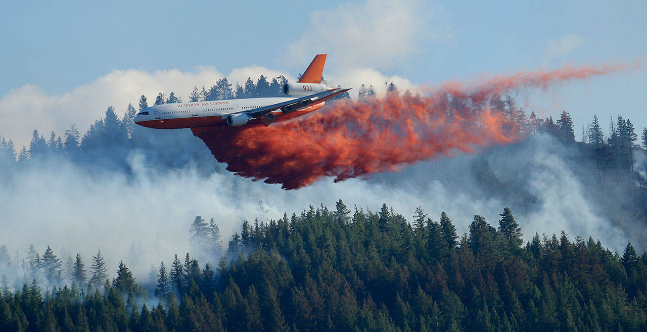 In this Aug. 21, 2015, file photo, a tanker airplane drops fire retardant on a wildfire burning near Twisp. (Ted S. Warren/The Associated Press)