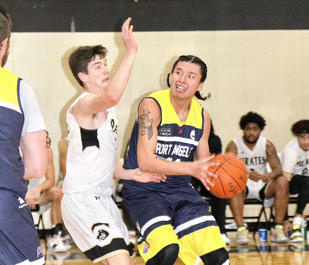 Michael Janis of the Port Angeles Rams, right, looks to pass while being guarded by Gabe Long of the Peninsula College Pirates. (Dave Logan/for Peninsula Daily News)