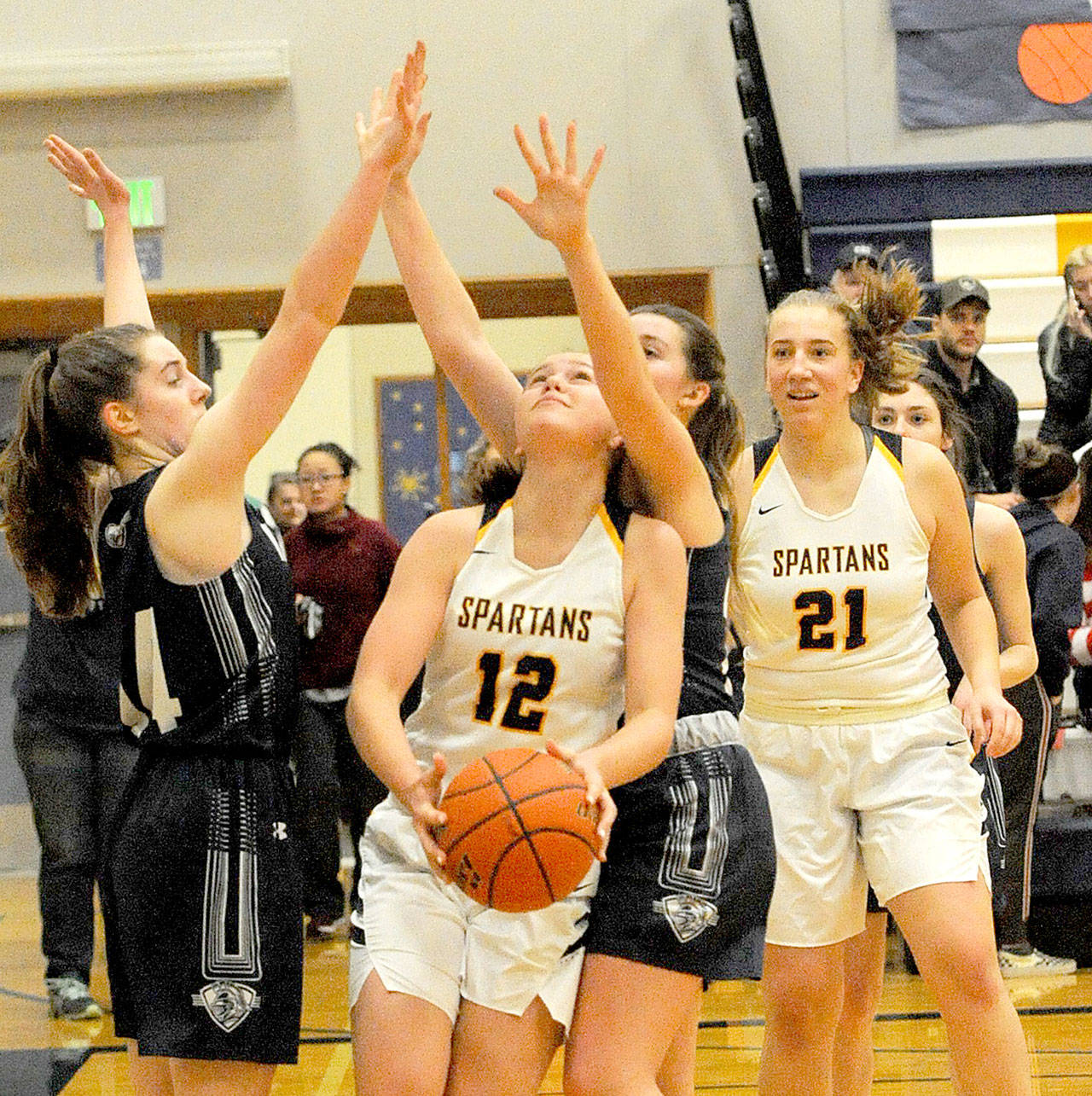 Lonnie Archibald/for Peninsula Daily News Spartan Kray Horton (12) looks to shoot against King’s Way Christian in Forks on Saturday as the Spartans won 57-54. Looking on is Horton’s teammate Chloe Leverington (21).