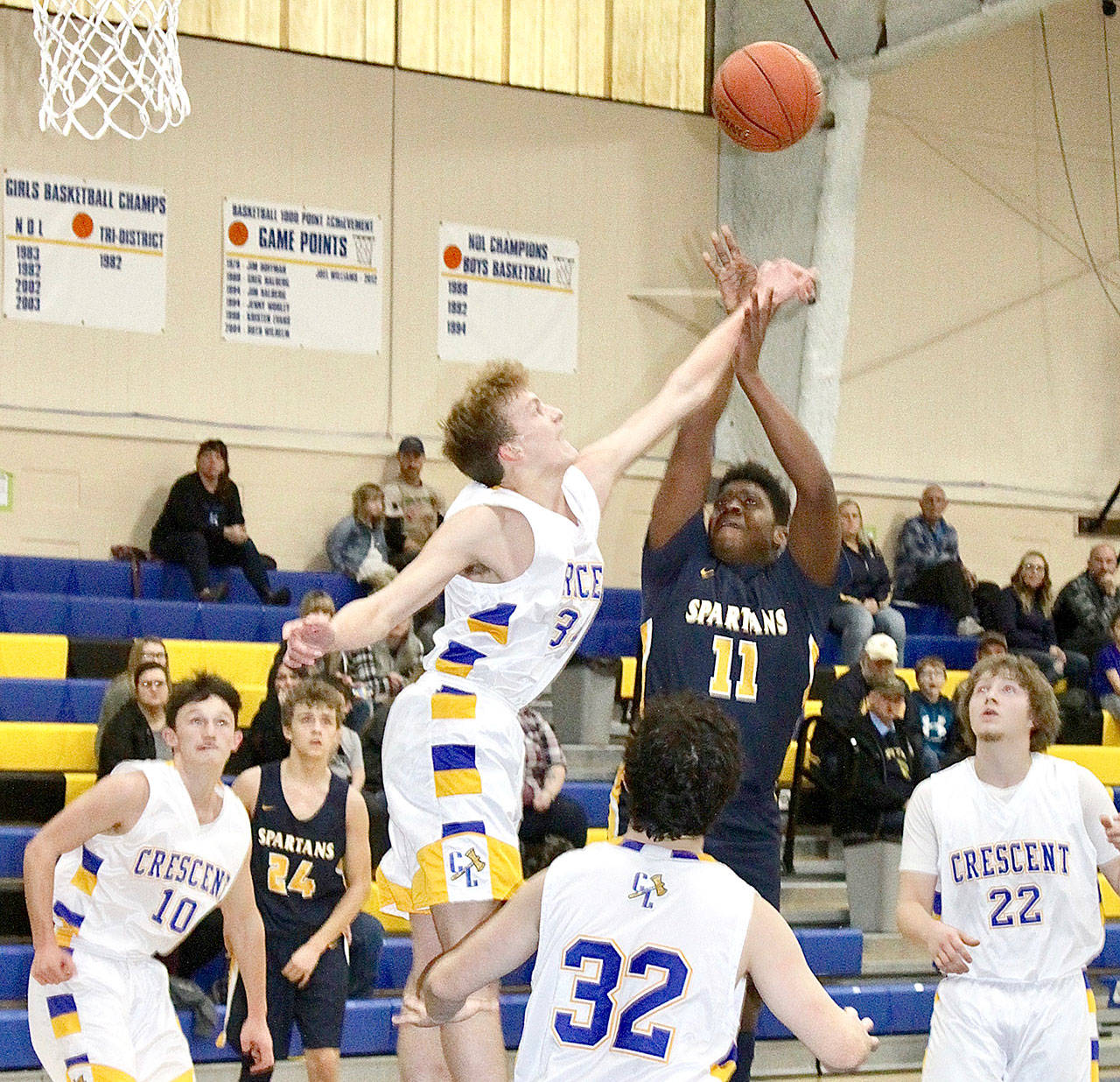 Trey Baysinger (11) of Forks goes up for a shot but Gabe Ritchie of Crescent tries to block it. Others watching are Crescent’s Brayden Emery (10), Tim Ward (32), and Mason Owens (22), and Forks’ Logan Olson (24). (Dave Logan/for Peninsula Daily News)