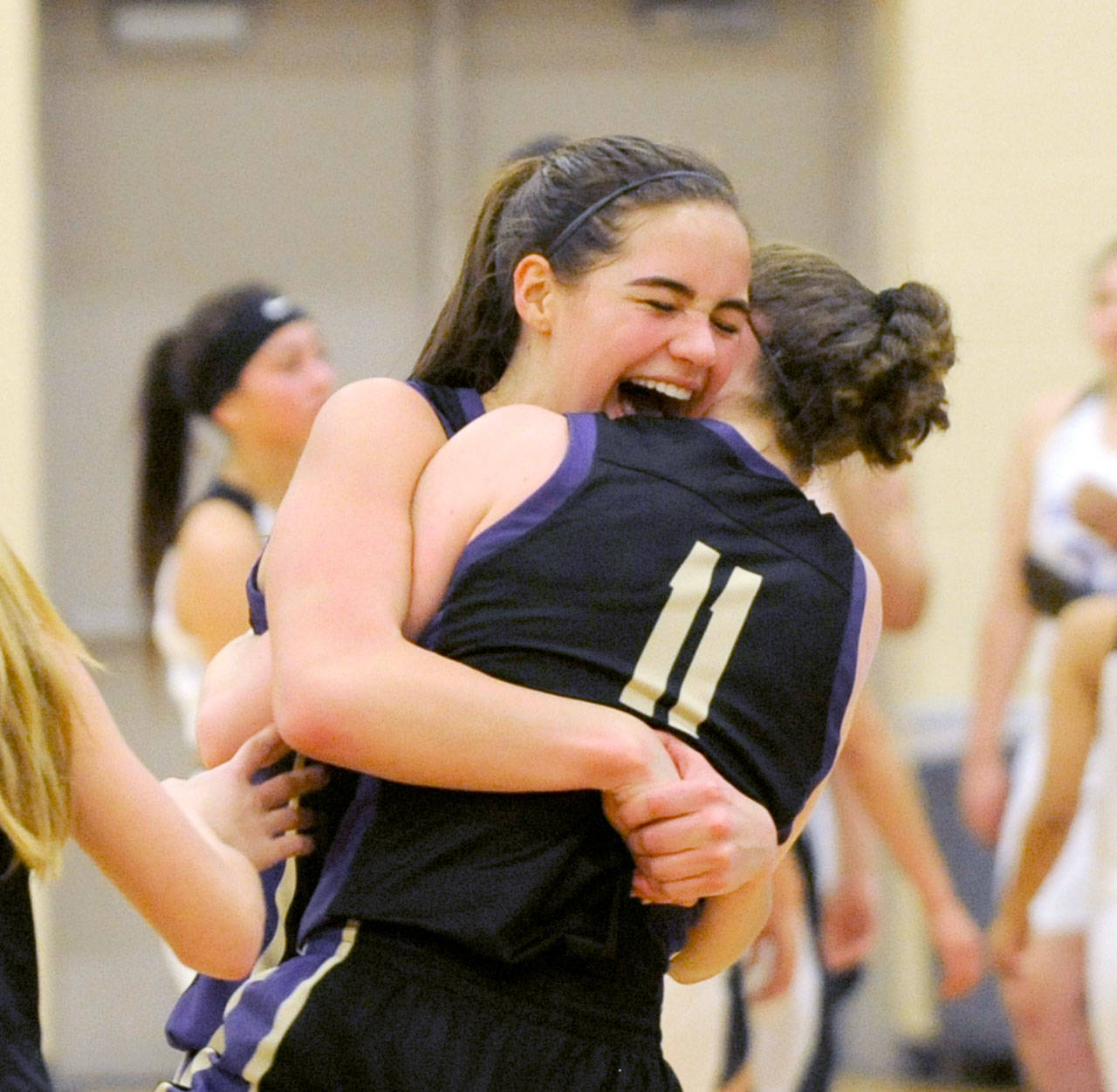 Sequim’s Hope Glasser, left, and Abby Schroeder celebrate the Wolves’ come-from-behind 54-44 victory over Foster to advance to the Class 2A State Tournament. (Michael Dashiell/Olympic Peninsula News Group)