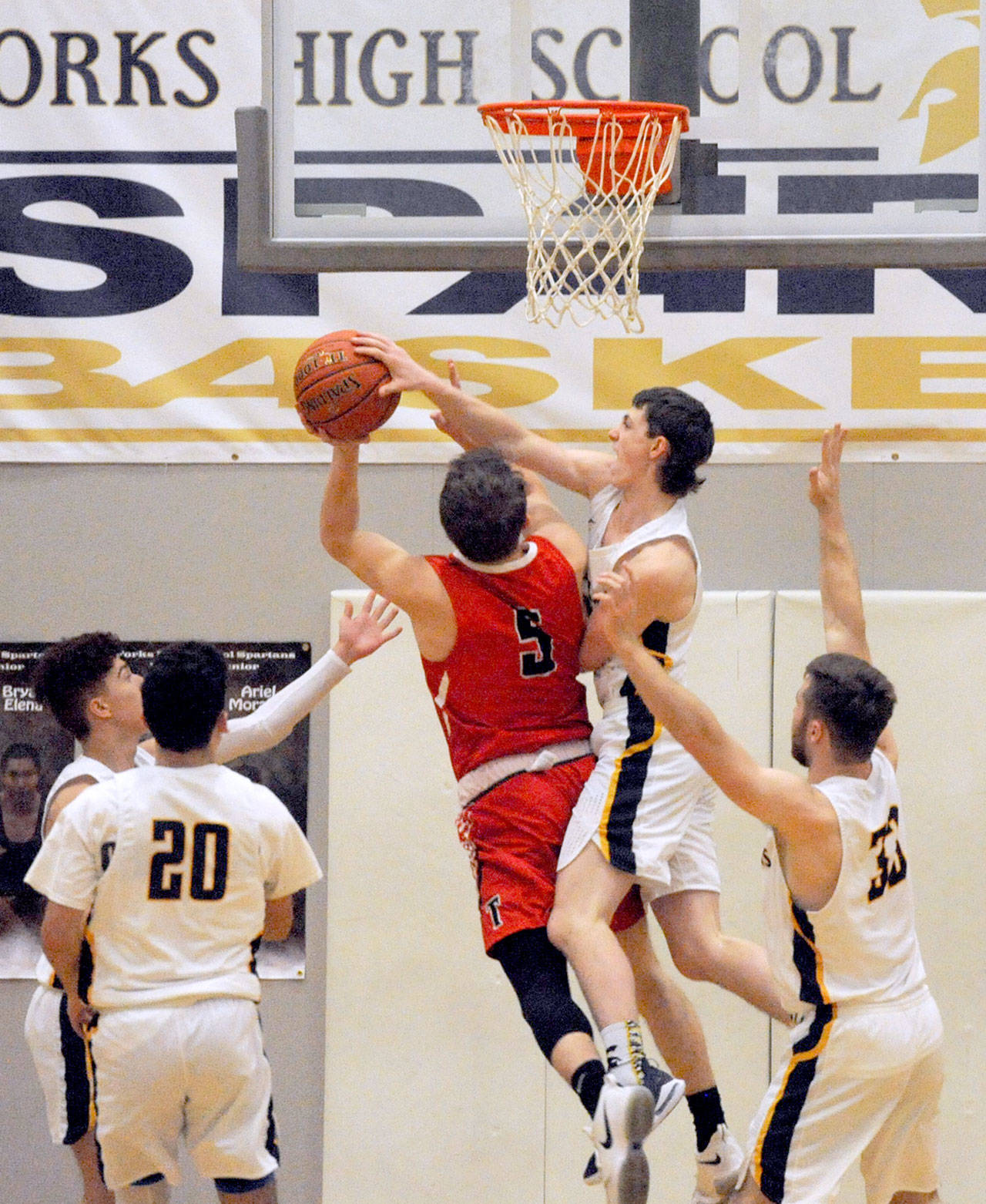 Forks’ Raymond Davis (right) blocks a shot put up by Tenino’s Logan Brewer (5) in the Spartans’ 63-48 win in the Evergreen League opener for each team. (Lonnie Archibald/for Peninsula Daily News)