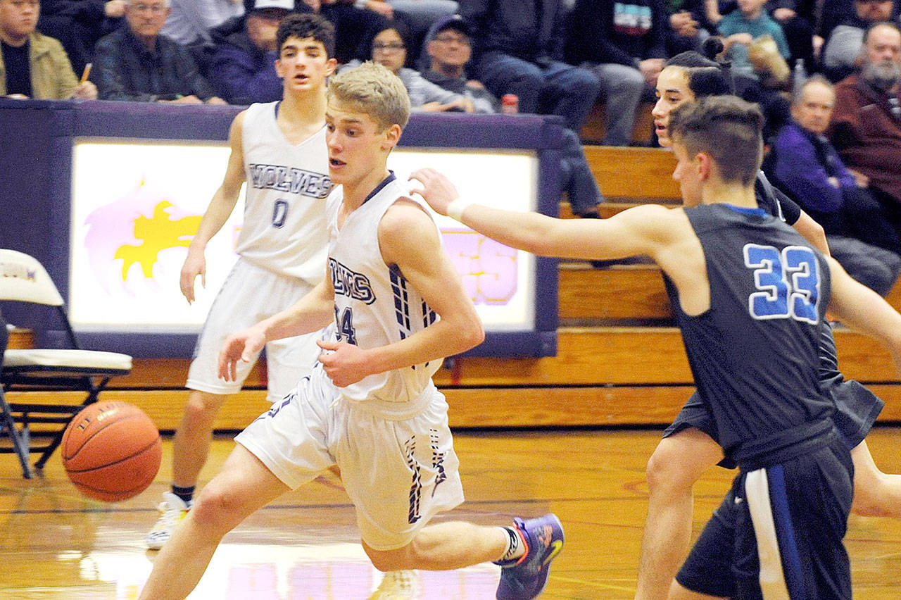 Sequim’s Erik Christiansen (34) tracks down the ball as teammate Dallin Despain looks on in the background. The Wolves hung on to beat Olympic 51-49. (Conor Dowley/Olympic Peninsula News Group)