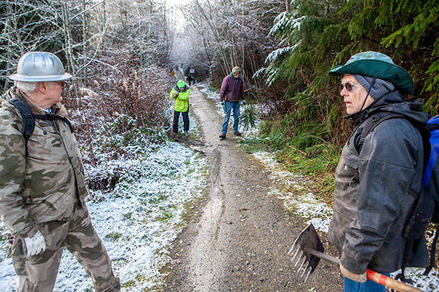 Bill Mueller of Port Angeles, right, and Tom Mix of Sequim discuss their next project along the Adventure Trail just west of the Elwha River bridge. The crew, which works each Thursday, began in the early morning, just after a wet snowfall. (Bob Martinson/for Peninsula Daily News)