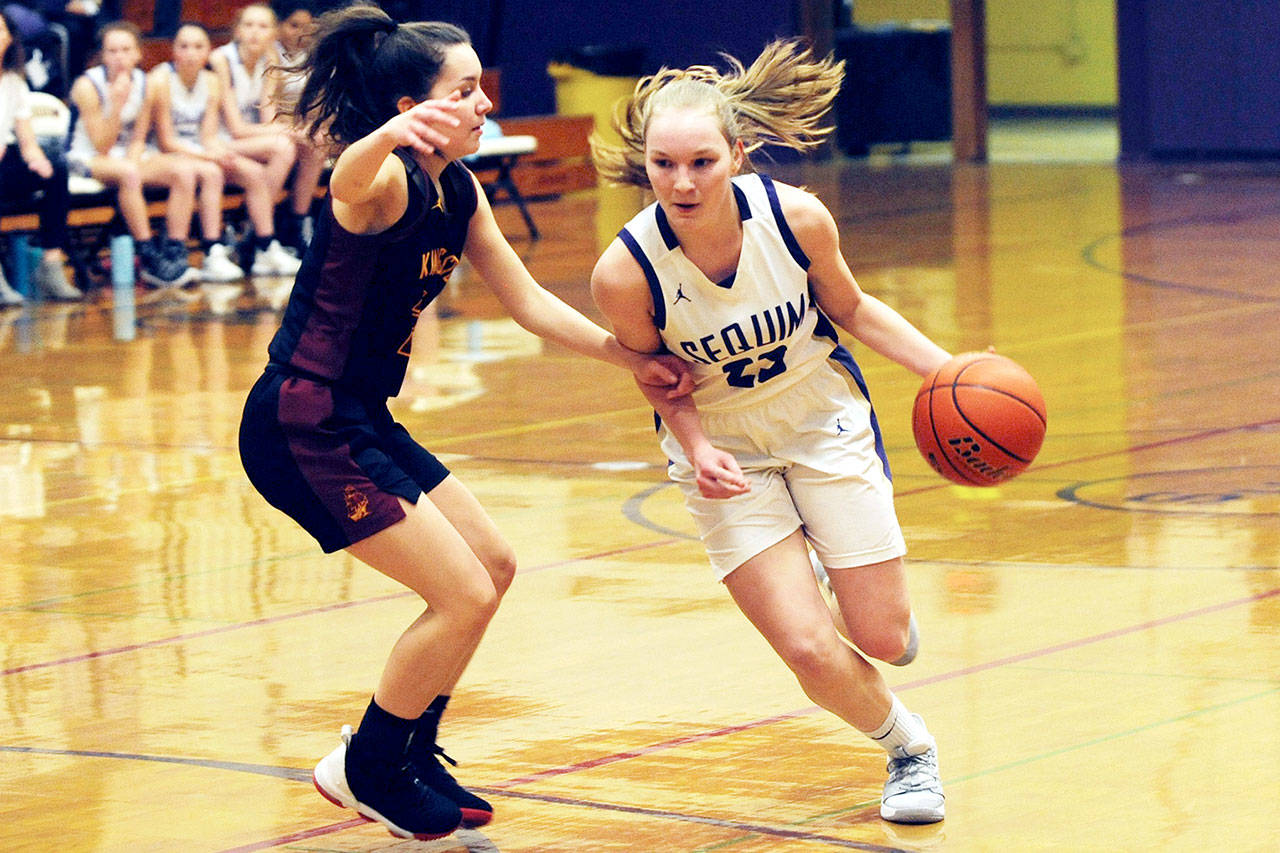 Sequim Wolves wing Melissa Porter (right) looks to drive against Kingston Buccaneers guard Suzanne Skinner (left) in the first quarter of the Wolves’ 87-42 win over the Buccaneers on Jan. 17. Porter lead the scoring for the Wolves with 18 points, most of which came off fast breaks.                                Conor Dowley/Olympic Peninsula News Group