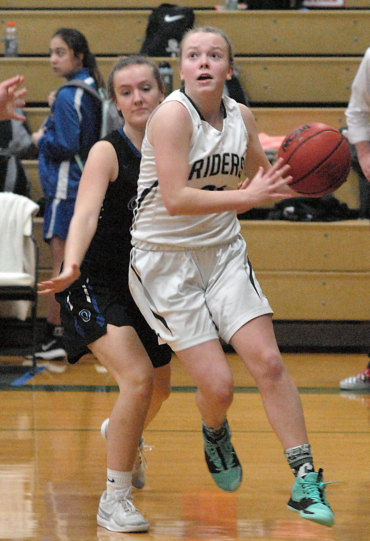 Keith Thorpe/Peninsula Daily News Anna Petty of Port Angeles, right, drives to the lane defended by Olympic’s Elisa Turnquist on Friday at Port Angeles High School.