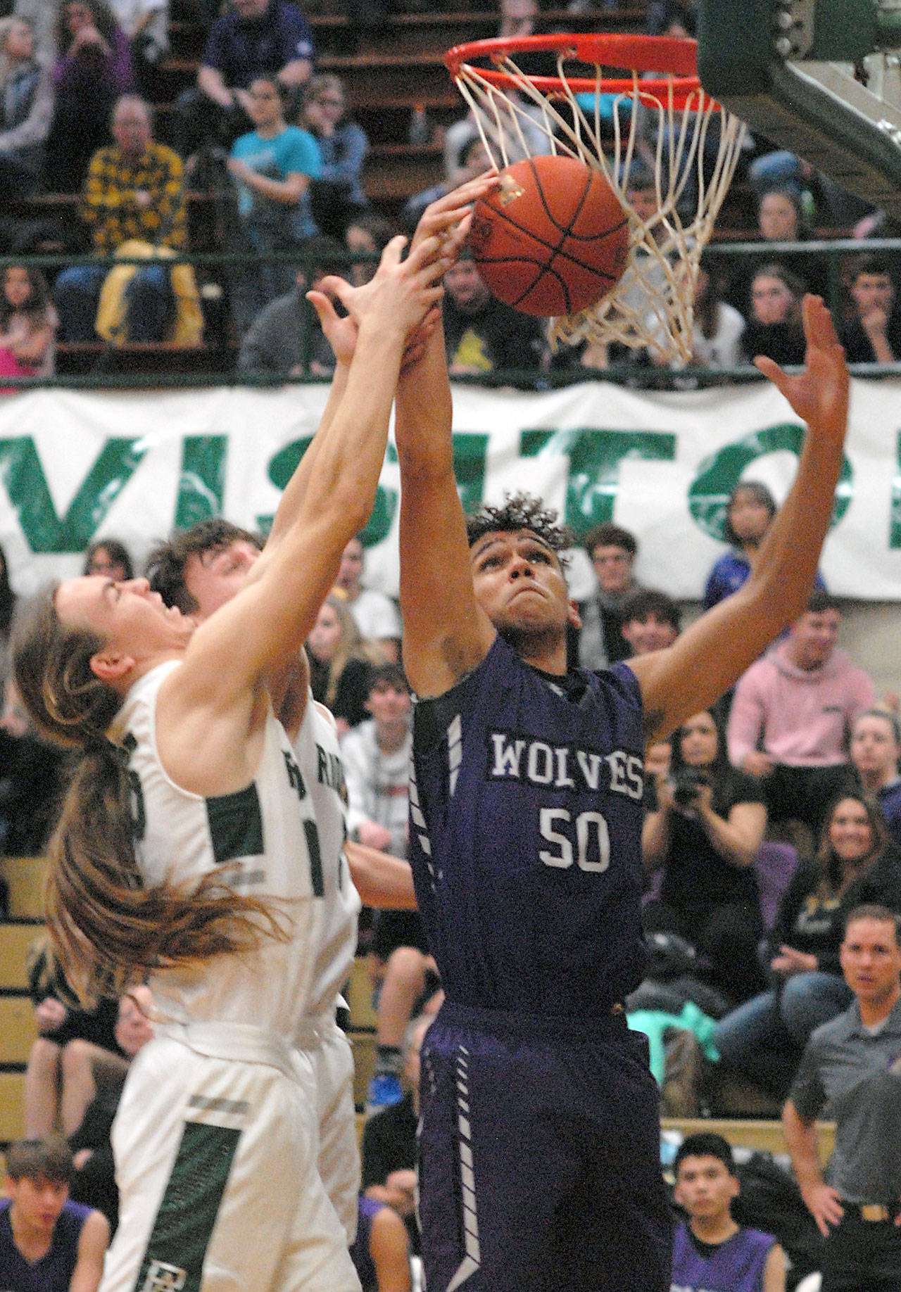 Keith Thorpe/Peninsula Daily News Port Angeles’ Derek Bowechop, left, and Gary Johnson battle for a rebound with Sequim’s Hayden Eaton on Thursday night at Port Angeles High School.