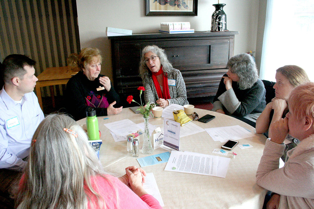 Liz Coker, center, the director of the Jefferson County Homebuilders Association, discusses potential solutions to the housing crisis with others Monday during the monthly luncheon hosted by the Chamber of Jefferson County at the Elks Lodge in Port Townsend. (Brian McLean/Peninsula Daily News)