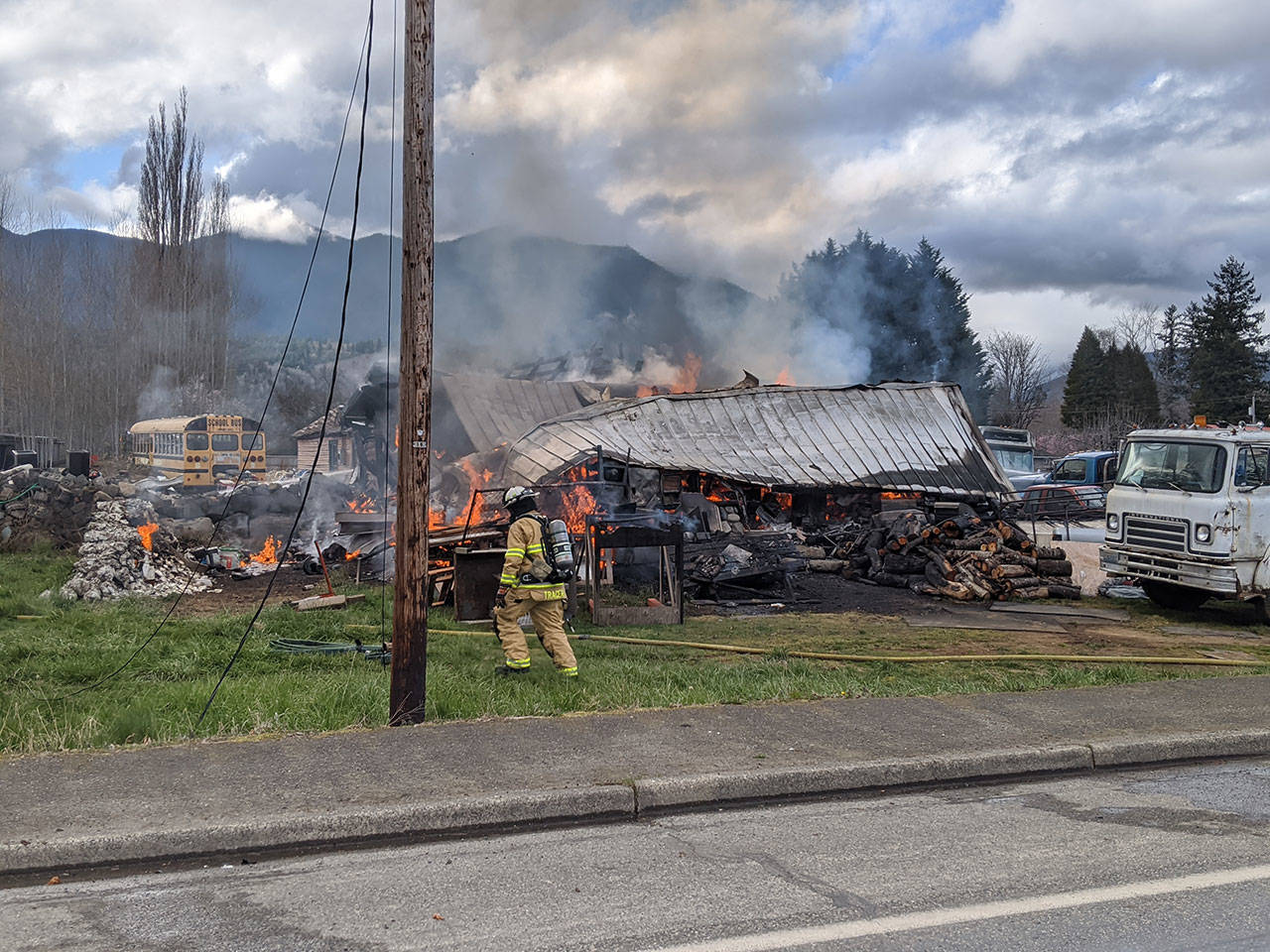 Firefighters work to extinguish a residential fire on Center Road near the intersection of Center Road and East Columbia Street. (Zach Jablonski/Peninsula Daily News)