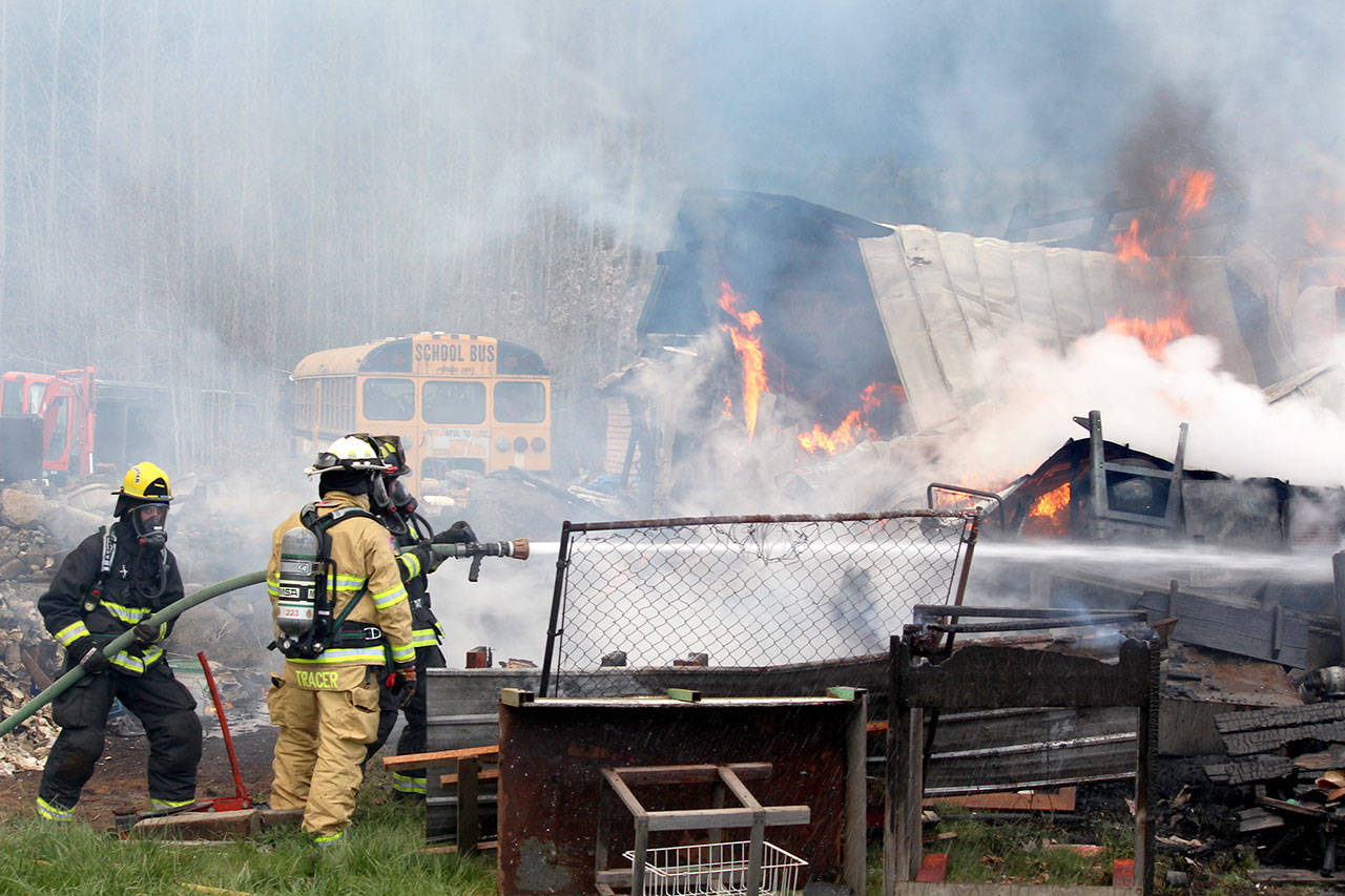 Firefighters work to extinguish a residential fire on Center Road near the intersection of Center Road and East Columbia Street. (Zach Jablonski/Peninsula Daily News)