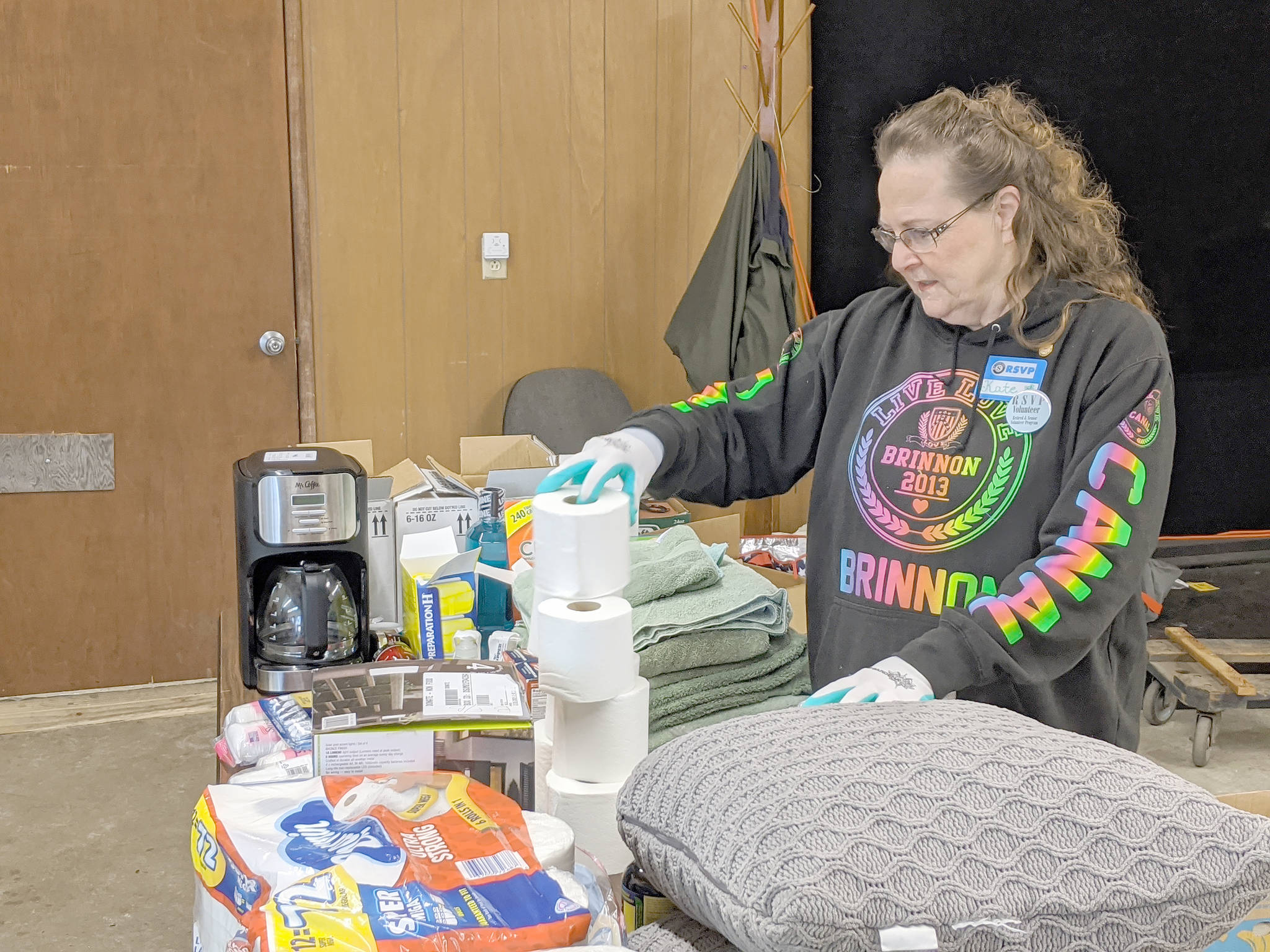 Long-time Brinnon Food Bank volunteer Kate Sullivan works to get items organized that will be given to clients of the Brinnon Food Bank on Tuesday morning. (Zach Jablonski/Peninsula Daily News)