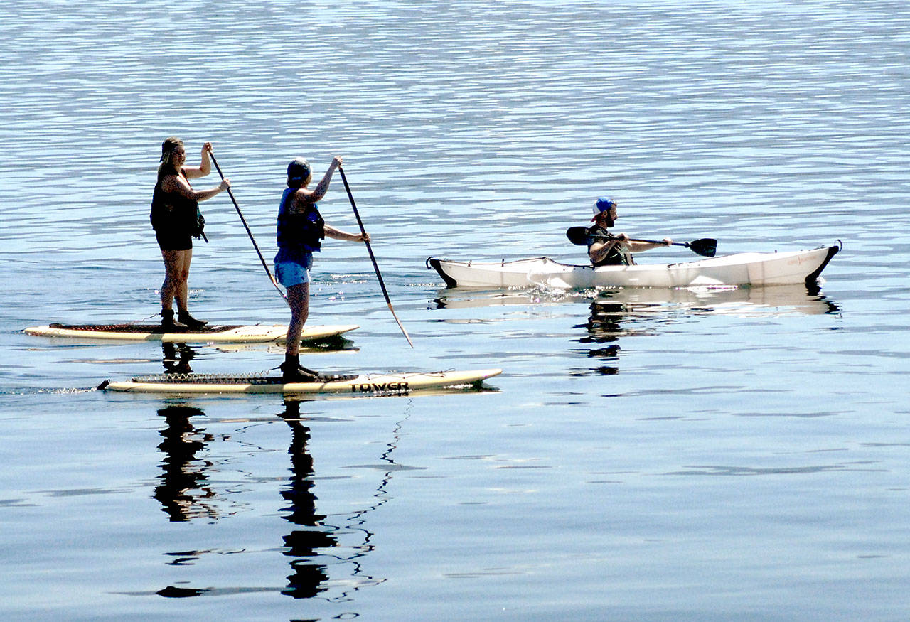 Paddlers, from left, Jennie Freese, Casey Fall and Eric Hoffman, all of Port Angeles, make their way across the mostly empty waters of Port Angeles Harbor in this April 16, 2020, file photo. All outdoor recreation involving fewer than five people outside one’s household is expected to open June 1 based on Gov. Jay Inslee’s current four-phase plan for reopening Washington. (Keith Thorpe/Peninsula Daily News file)