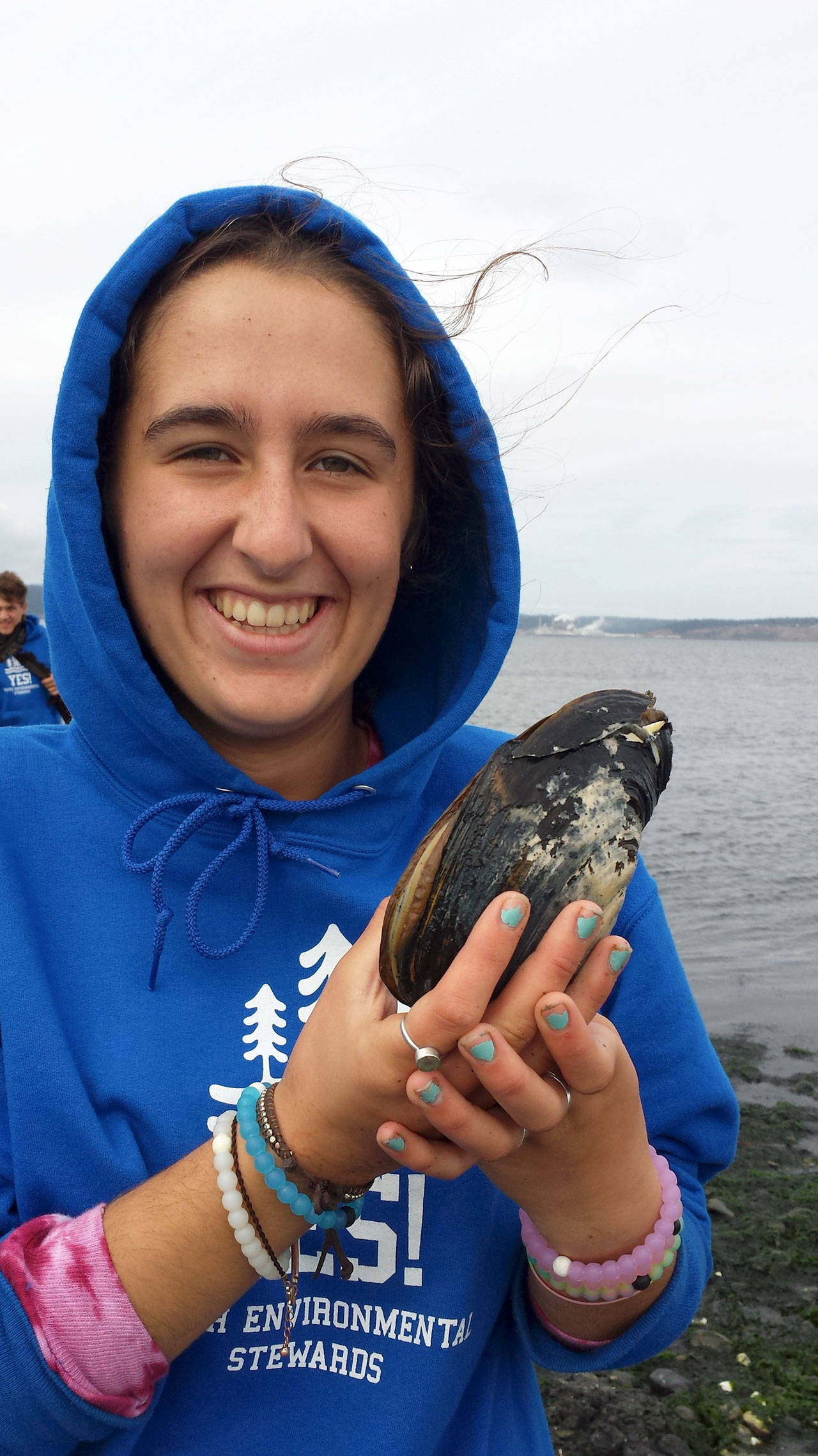 Mimi Molotsky shows off a horse clam during a Youth Environmental Stewards YES! Program held before the coronavirus pandemic. (Jude Rubin/Northwest Watershed Institute)