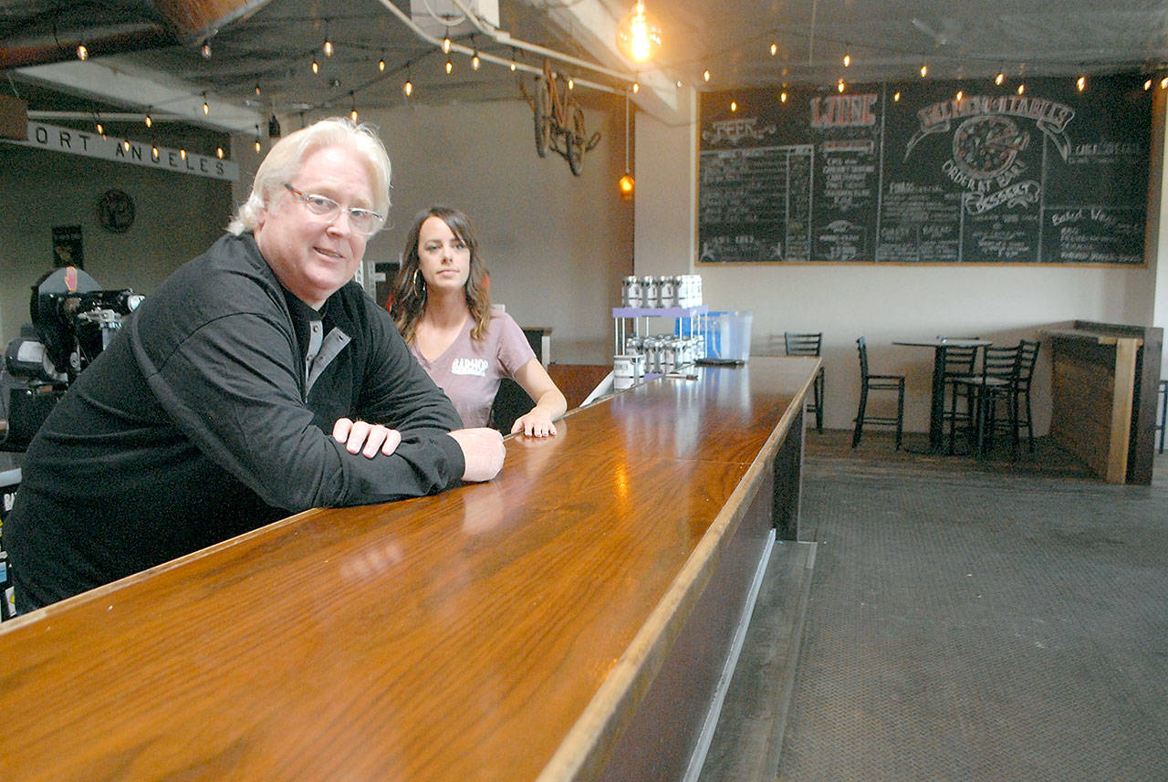 Tom Curry, owner of Barhop Brewing and Artisan Pizza, The Rail and the Barhop Brewery, along with Media Relations Director Natalie White, sit behind the Barhop bar, which will be devoid of seating when the resaturant opens next week. (Keith Thorpe/Peninsula Daily News)