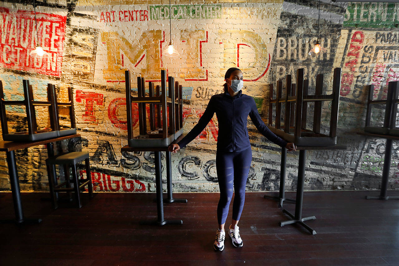 In this Thursday, May 21, 2020, image, Stephanie Byrd, co-owner of The Block, poses for a photo with chairs on the tables while the restaurant is closed due to the coronavirus in Detroit. She’s worried other black-owned businesses will struggle to withstand another wave of economic uncertainty during the pandemic, following decades of inequity that made it hard for many to flourish in the first place. (Paul Sancya/Associated Press)