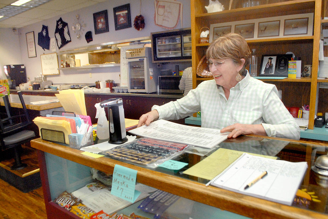 Dee Garner, a waitress and greeter at Joshua’s Restaurant and Lounge in Port Angeles, arranges menus at the eatery’s front counter Tuesday, June 2, 2020, after the establishment was allowed to reopen its dining room under Phase 2 of state COVID-19 guidelines. (Keith Thorpe/Peninsula Daily News)