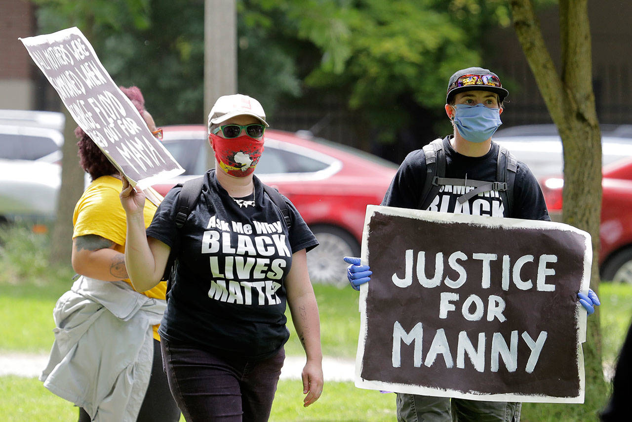 A protester holds a sign that reads “Justice for Manny” Friday, June 5, 2020, in Tacoma, Wash., during a protest against police brutality and the death of George Floyd, a black man who died after being restrained by Minneapolis police officers on May 25. On Thursday, the mayor of Tacoma called for the firing of police officers involved in the death of Manuel Ellis, who died March 3 while being held down by Tacoma police, after the Pierce County medical examiner’s office determined that the restraint caused his death. (AP Photo/Ted S. Warren)