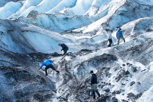 In this June 18, 2020, photo provided by U.S. Air Force Mortuary Affairs Operations, crash recovery team personnel assigned to Joint Base Elmendorf-Richardson, Alaska, search for crash remains at Colony Glacier, Alaska. A military plane carrying 41 passengers and 11 crew members crashed into a mountain near Anchorage in 1952, but remains of the victims are still being discovered. (Senior Airman Jonathan Valdes Montijo/U.S. Air Force via AP)