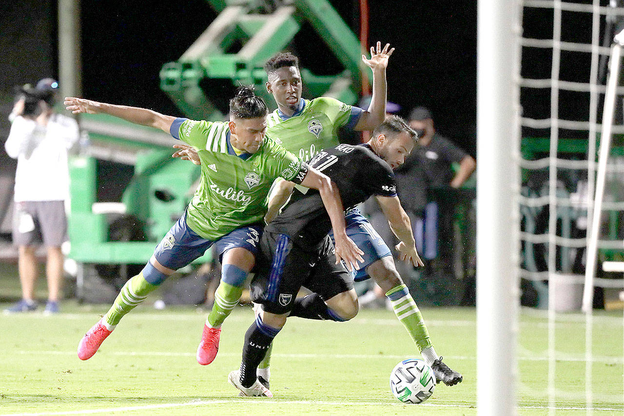 Seattle Sounders defender Xavier Arreaga, left, and defender Kelvin Leerdam, center rear, prevent San Jose Earthquakes midfielder Vako from scoring during the second half of an MLS soccer match, Friday, July 10, 2020, in Kissimmee, Fla. (AP Photo/John Raoux)