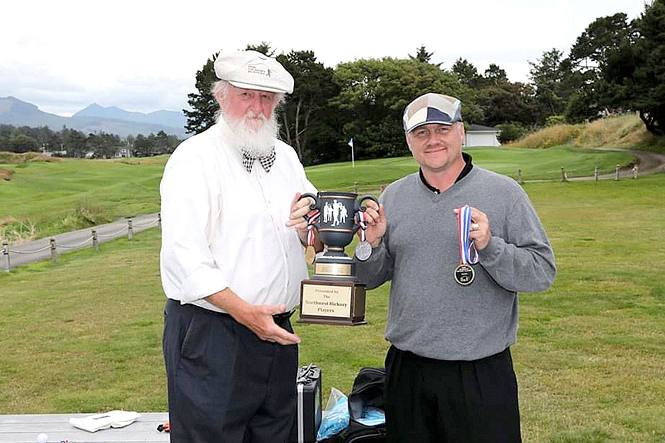 Gabe Tonan from Port Townsend, right, receives his trophy for winning the Gearhart Hickory Classic in Gearhart, Ore., on July 11.