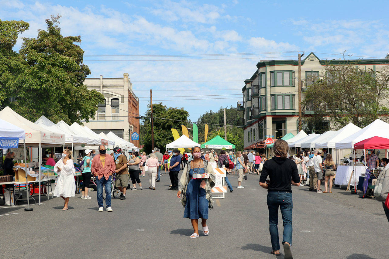 Shoppers visit vendor booths at the Port Townsend Farmers Market on Saturday. A regular at the Port Townsend market has committed to covering vendor fees at markets in Port Townsend and Chimacum to help struggling farmers and the market nonprofit. (Ken Park/Peninsula Daily News)