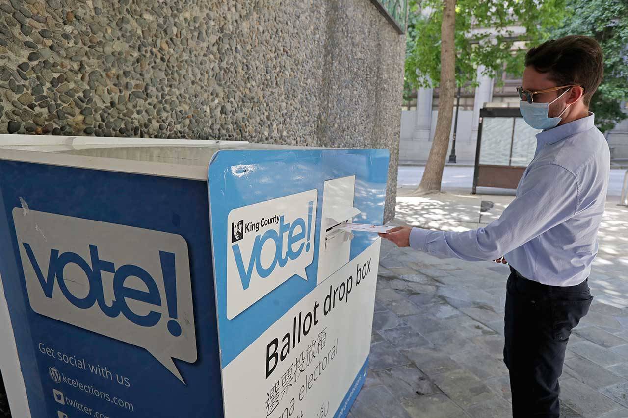 A person drops off a ballot for Washington state’s primary election on Tuesday at a collection box at the King County Administration Building in Seattle. Voters in the state have the option of voting by mail, depositing ballots in boxes or seeking help in person for a missing ballot or other issues. (Ted S. Warren/The Associated Press)