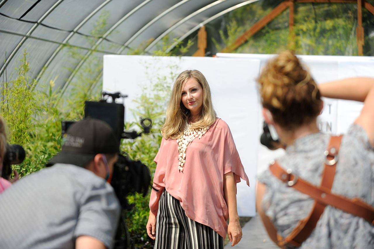 Videographer Silas Crews and photographers Julie Lawrence and Cindy Roth capture Lindsay Sué as she walks the runway for Impact Fashion’s show in New Dungeness Nursery. (Matthew Nash /Olympic Peninsula News Group)